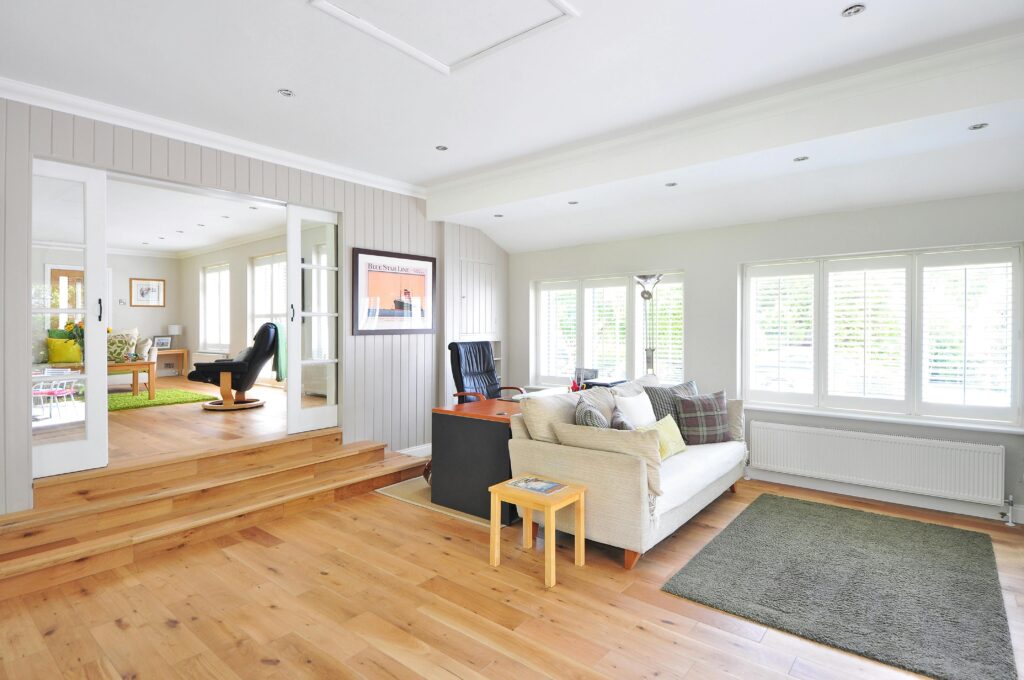 Spacious and bright modern living room with wooden floors and stylish furniture.